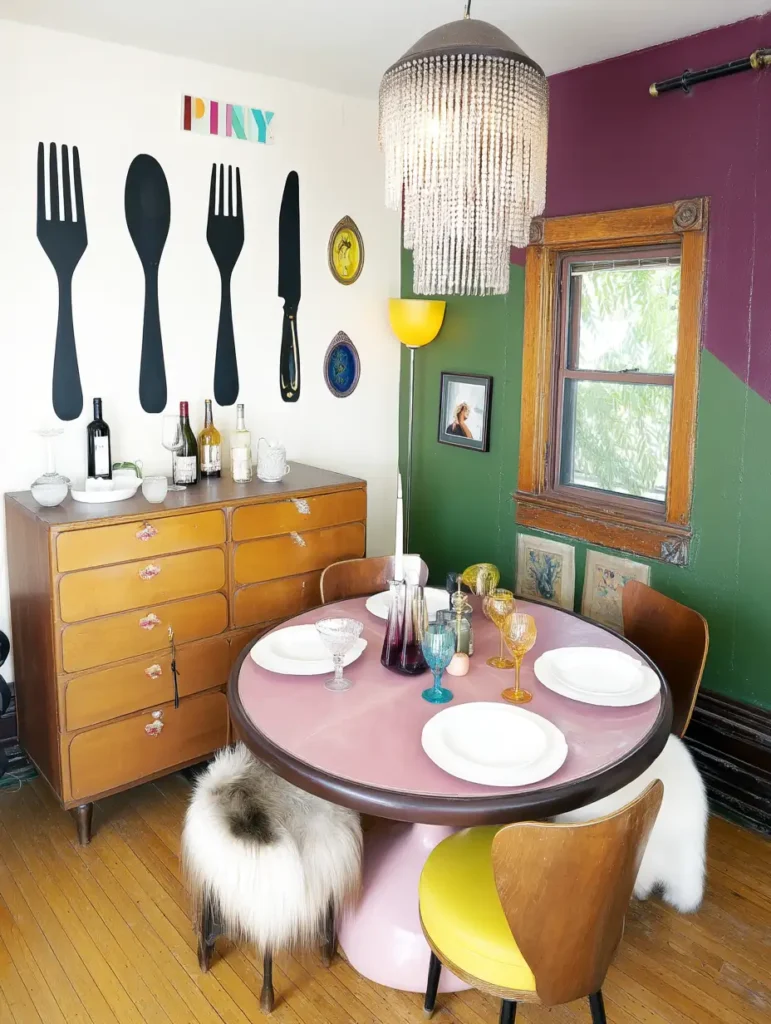 A vibrant dining room with oversized ceramic fork and spoon wall decor, adding a playful touch to the space.